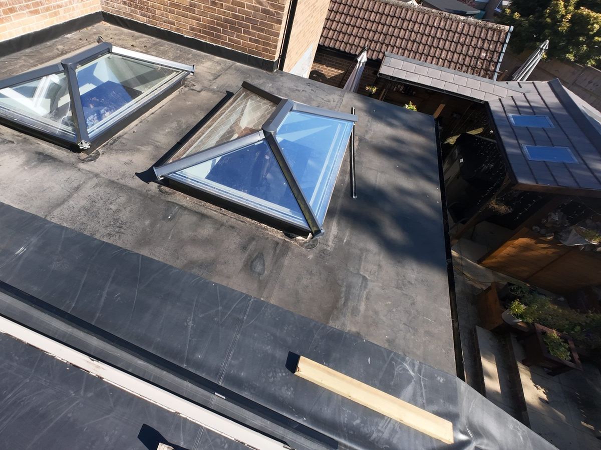 New EPDM rubber flat roof dressed around two glass roof lanterns